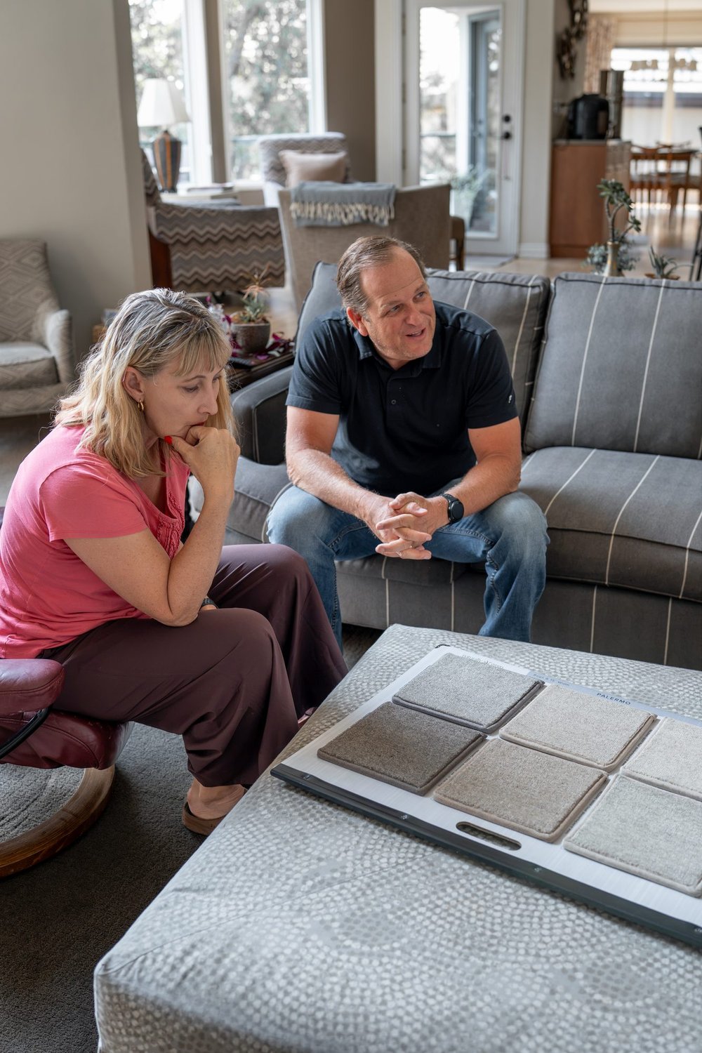 Homeowners comparing carpet colors and textures during an in-home carpet selection in the Treasure Valley