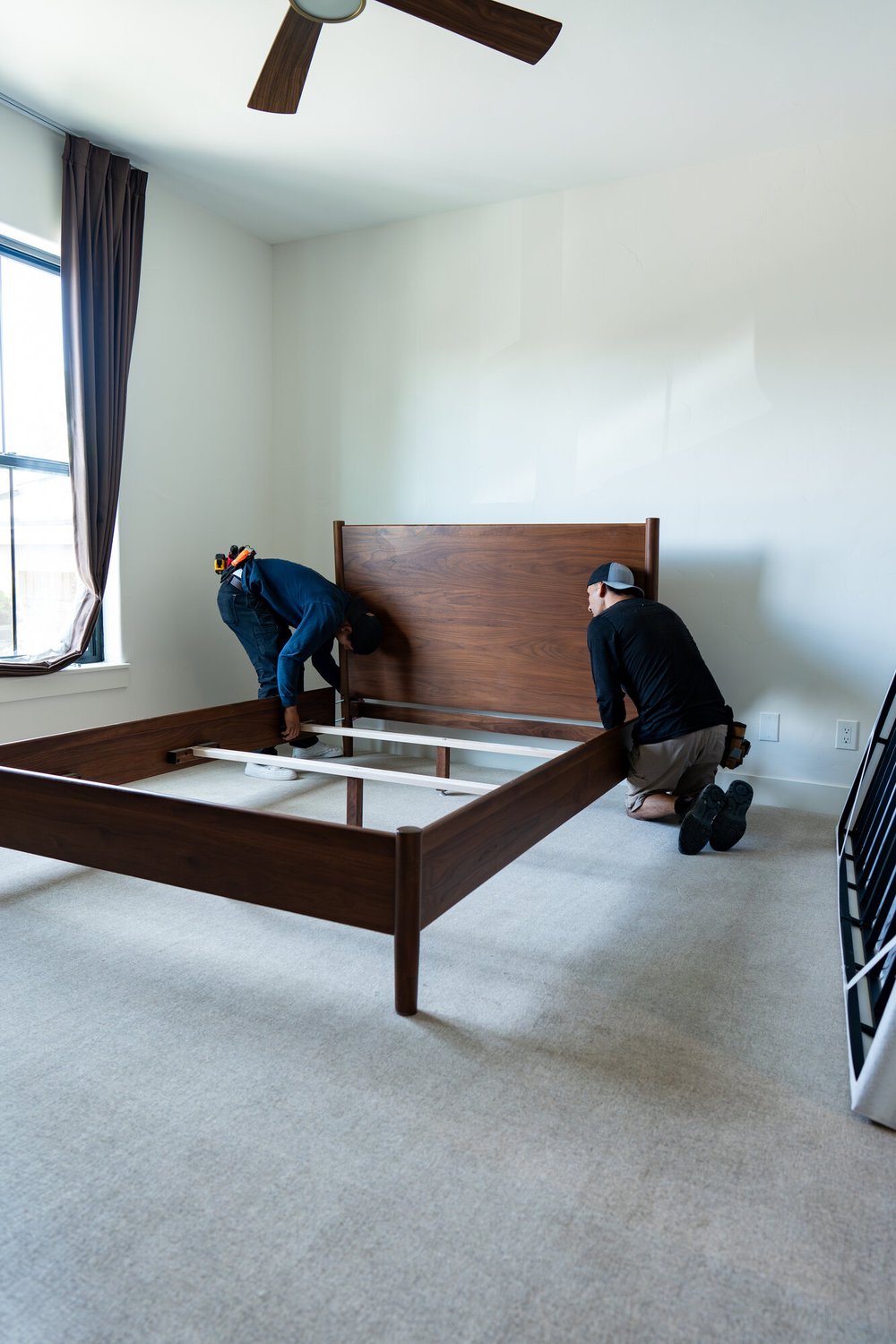 Origin Carpet installers reassembling a bed frame on newly installed carpet in a Treasure Valley home